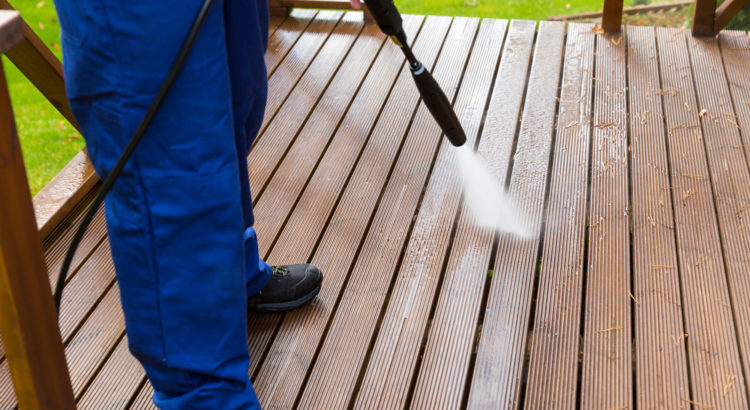 cleaning wooden terrace with high pressure washer