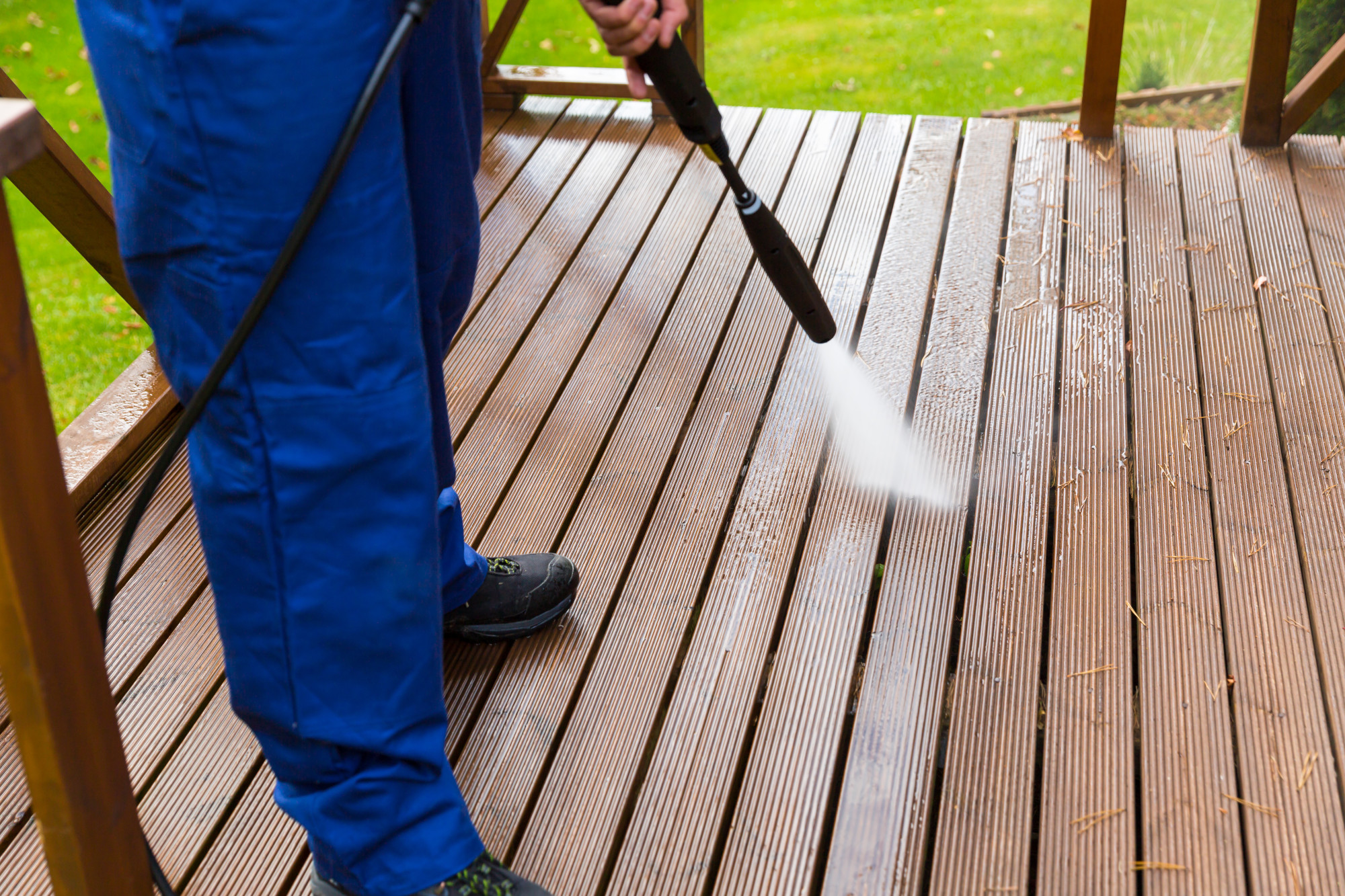 cleaning wooden terrace with high pressure washer